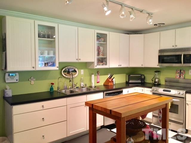 719 Beaver Dam Road Raleigh, NC 27607 - Photo 8 of 13 a kitchen with a stove a sink and cabinets