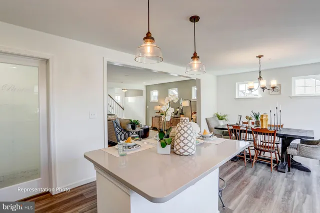 a view of a dining room and livingroom with furniture wooden floor a chandelier
