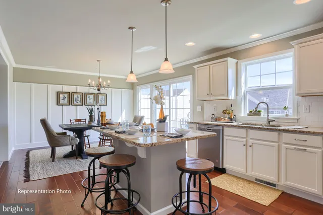 a kitchen with a dining table chairs sink and cabinets