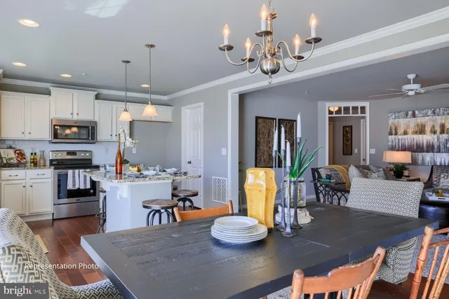 a kitchen with stainless steel appliances granite countertop a refrigerator dining table and chairs