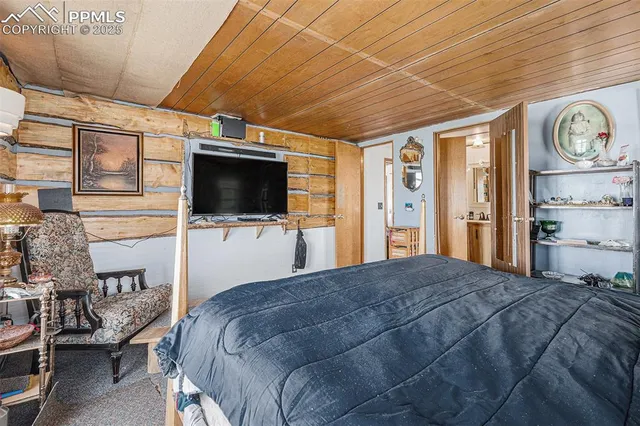 a bed room with a bed a television and dresser