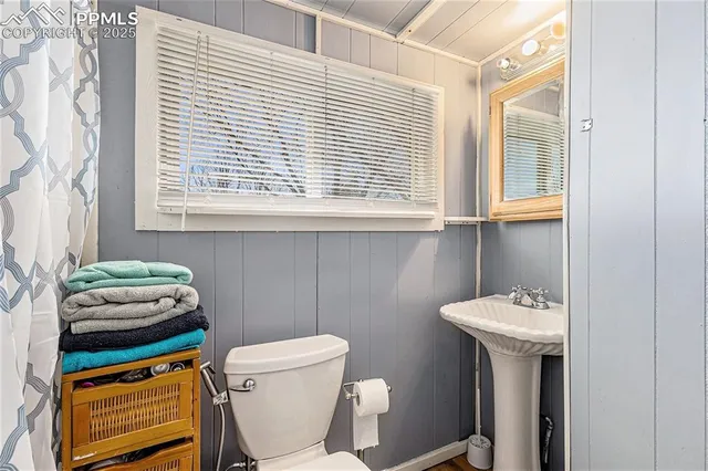 a bathroom with a sink a toilet and a window