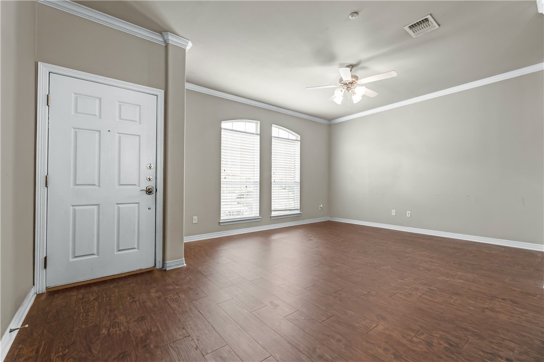 1198 Jones-Butler Road, Unit 606 College Station, TX 77840 - Photo 3 of 32 an empty room with wooden floor chandelier fan and windows