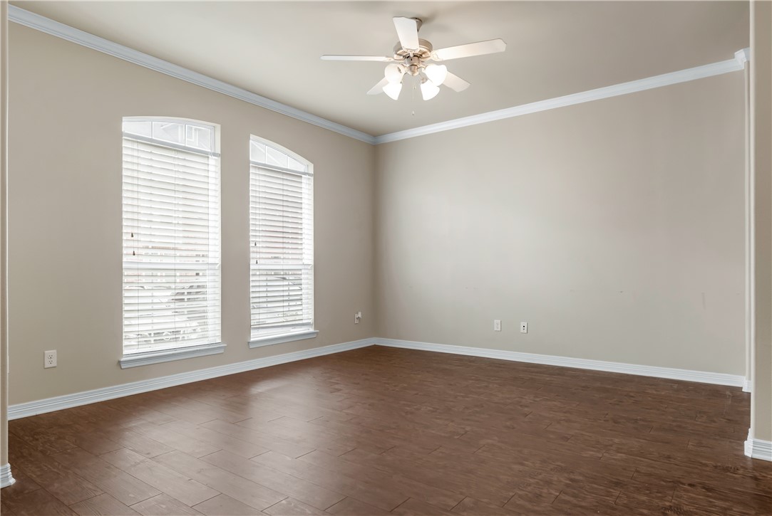 1198 Jones-Butler Road, Unit 606 College Station, TX 77840 - Photo 4 of 32 an empty room with wooden floor chandelier fan and windows