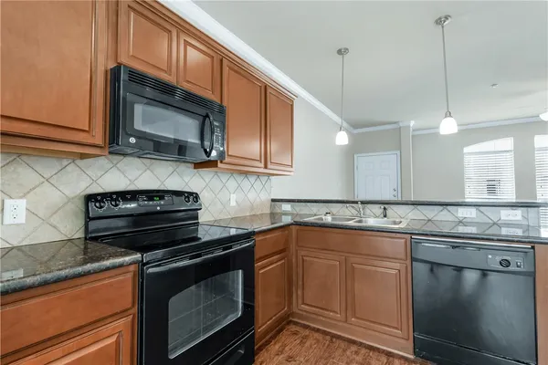 a kitchen with stainless steel appliances granite countertop a sink stove and microwave