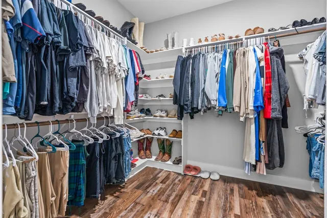 a view of walk in closet with clothes and shoes