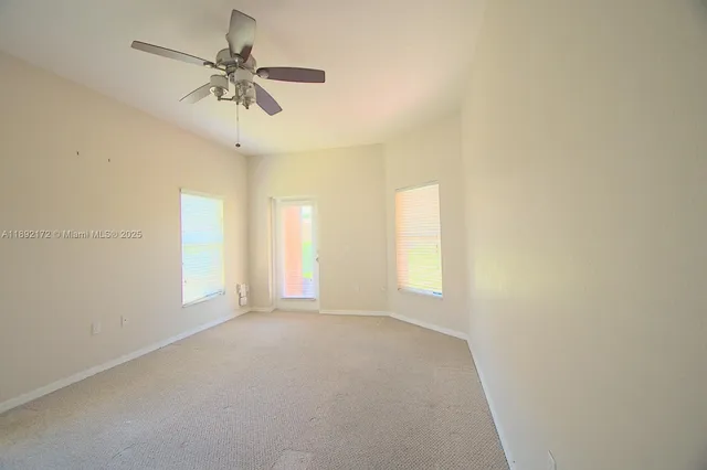a view of a livingroom with a chandelier fan and a window