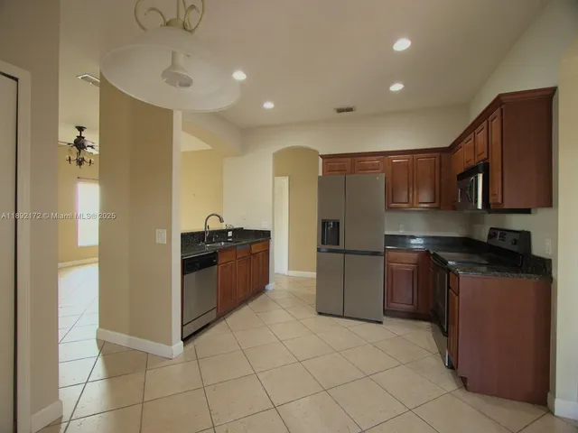 a kitchen with stainless steel appliances granite countertop a refrigerator sink and stove