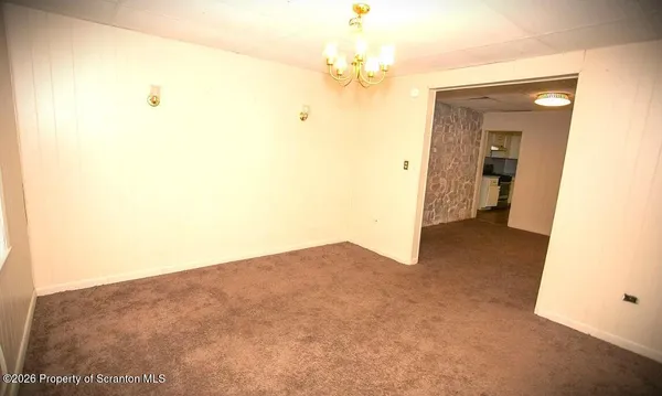 a view of a big room with windows and chandelier