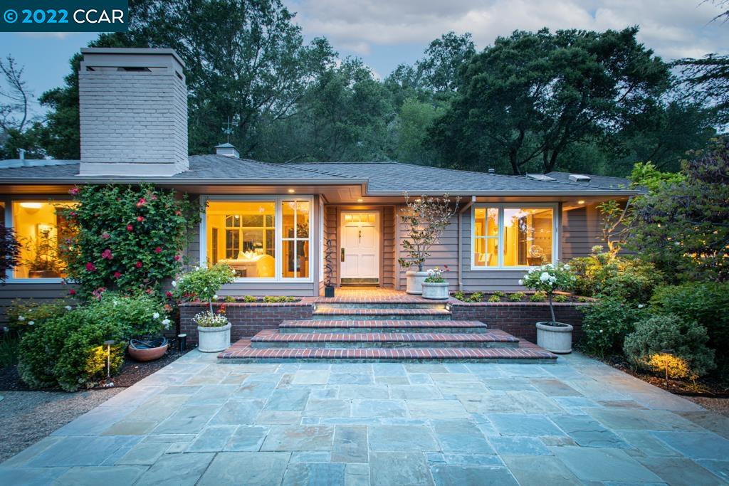 a front view of a house with a yard and a garden