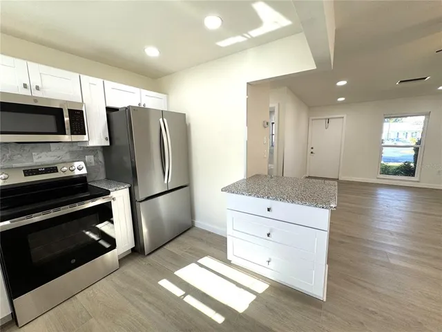 a kitchen with stainless steel appliances a refrigerator sink and microwave