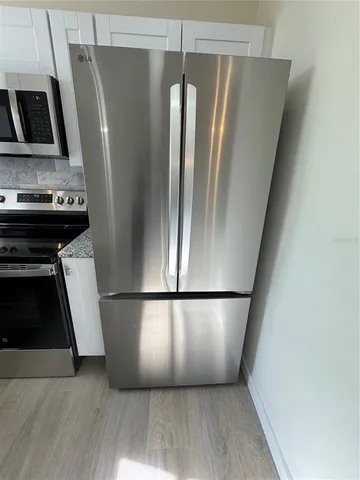 a view of a kitchen with wooden floor and a refrigerator