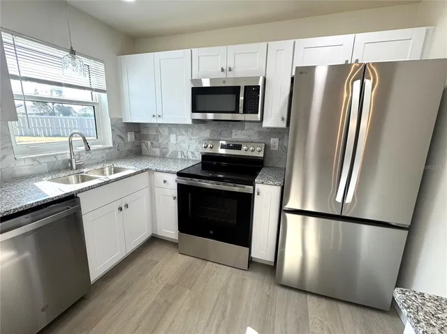 a kitchen with a refrigerator sink and microwave