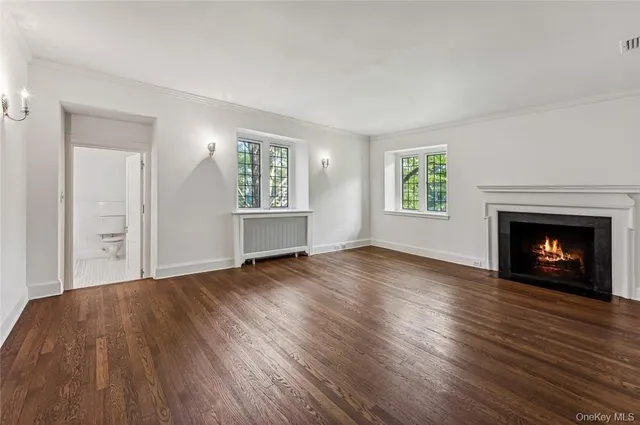an empty room with windows and a fireplace