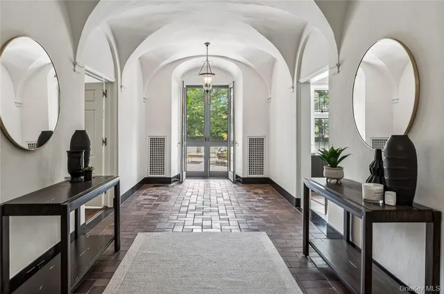 a view of hall way with mirror and furniture
