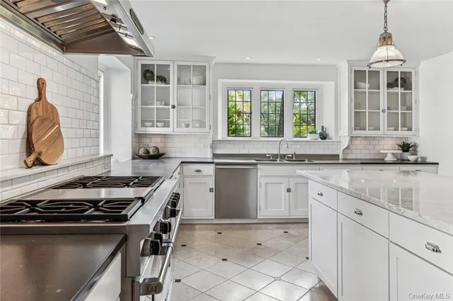 a kitchen with a stove a sink and a window