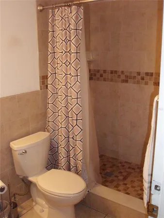a bathroom with a toilet and a shower