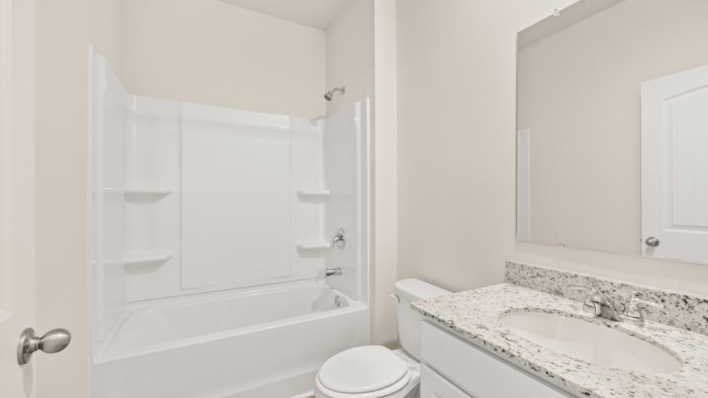 6008 Muirfield Point Union City, GA 30213 - Photo 13 of 29 a bathroom with a granite countertop toilet sink and bathtub