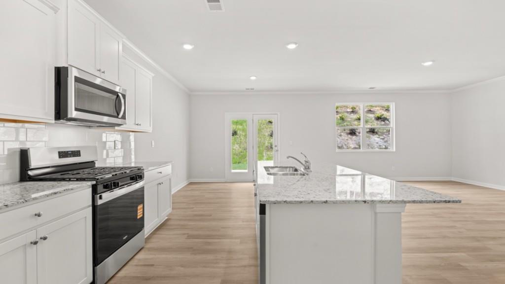 6008 Muirfield Point Union City, GA 30213 - Photo 6 of 29 a kitchen with granite countertop white cabinets and stainless steel appliances
