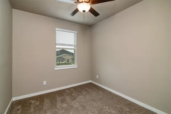 an empty room with a window and a ceiling fan