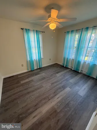 an empty room with wooden floor and window
