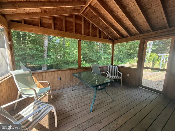 a patio with glass top table and chairs