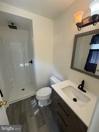 a bathroom with a sink toilet a mirror and shower