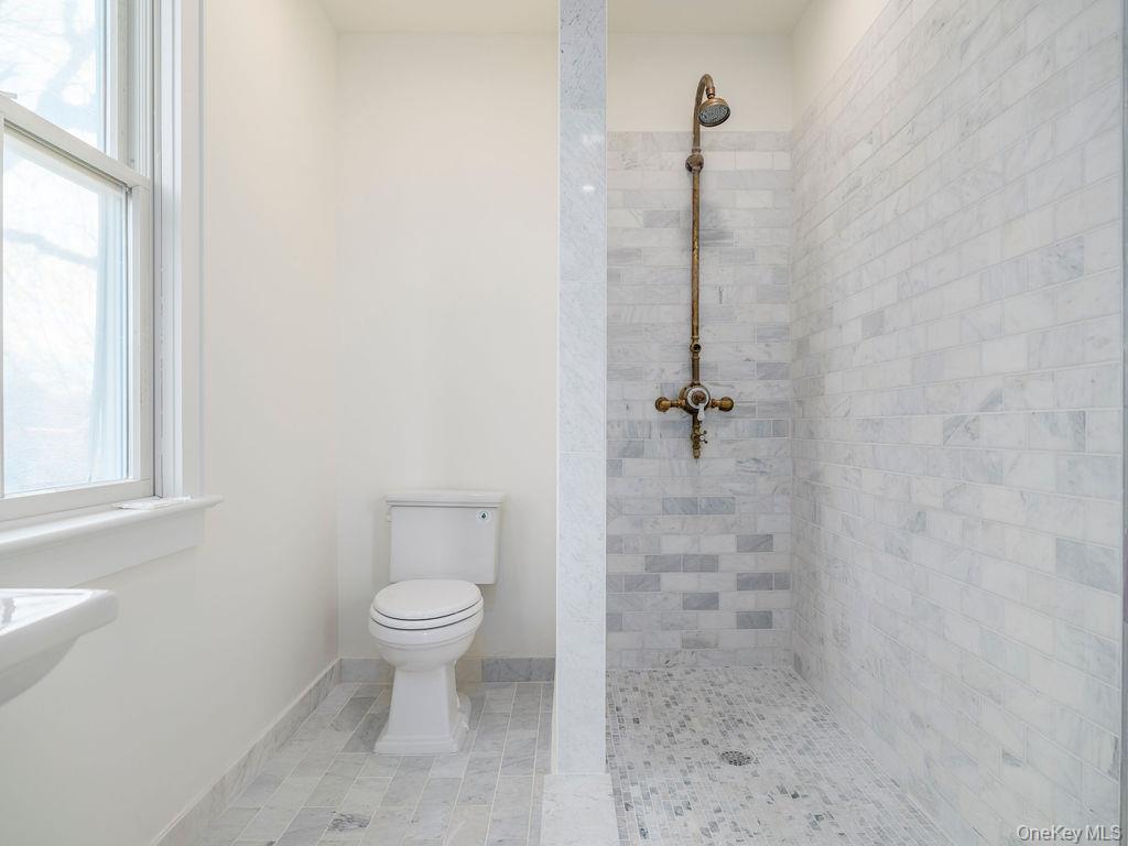 7220 Main Road East Marion, NY 11939 - Photo 37 of 44 a bathroom with a granite countertop toilet a sink and shower