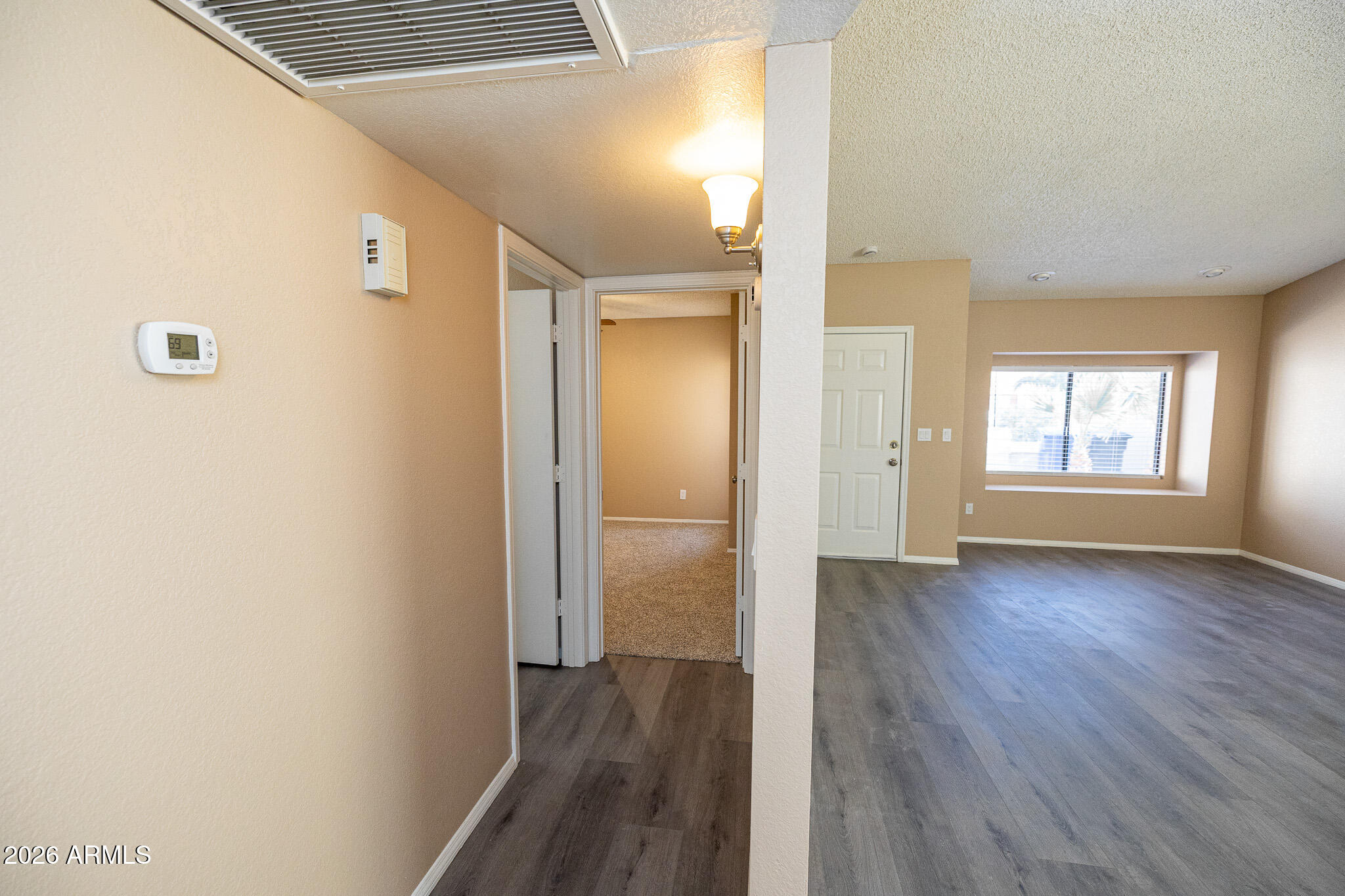 542 South Higley Road, Unit 104 Mesa, AZ 85206 - Photo 14 of 22 a view of an empty room with wooden floor and a window