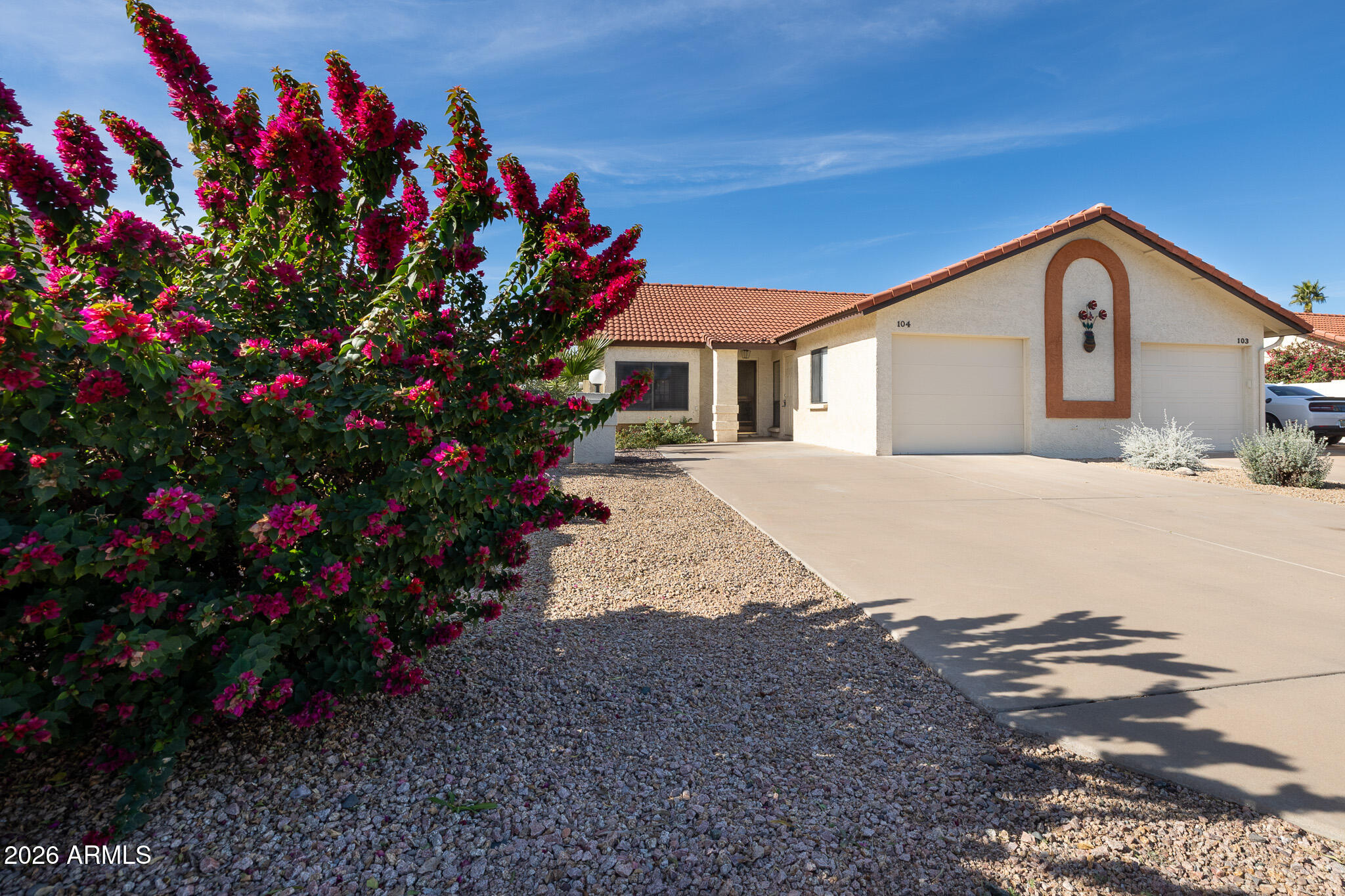 542 South Higley Road, Unit 104 Mesa, AZ 85206 - Photo 2 of 22 a front view of a house with a yard and flowers