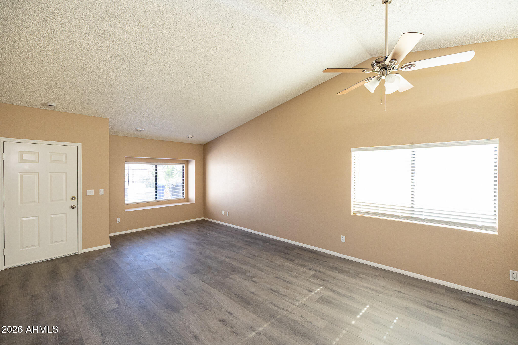 542 South Higley Road, Unit 104 Mesa, AZ 85206 - Photo 5 of 22 an empty room with wooden floor windows and fan