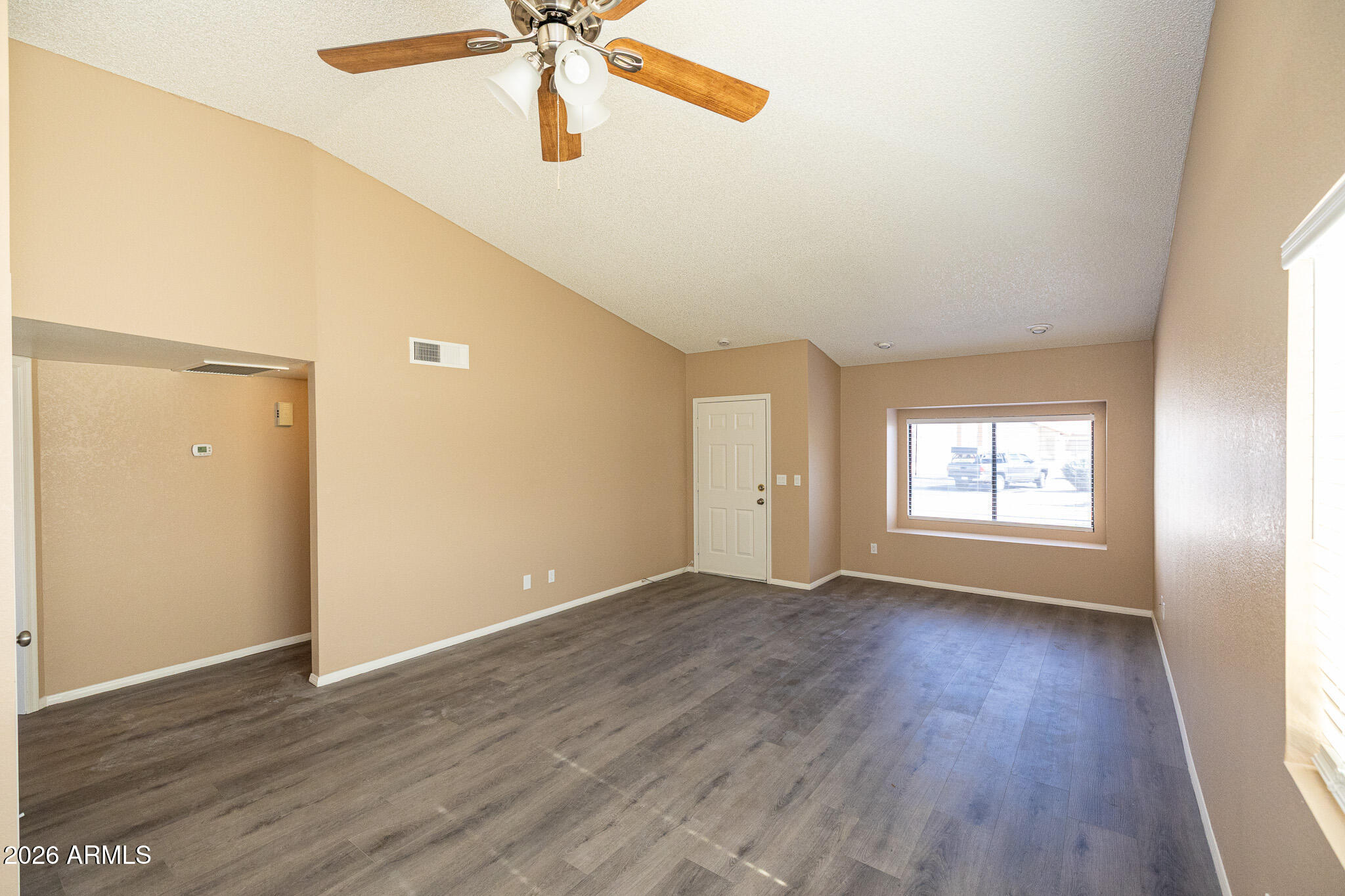 542 South Higley Road, Unit 104 Mesa, AZ 85206 - Photo 6 of 22 an empty room with wooden floor fan and windows