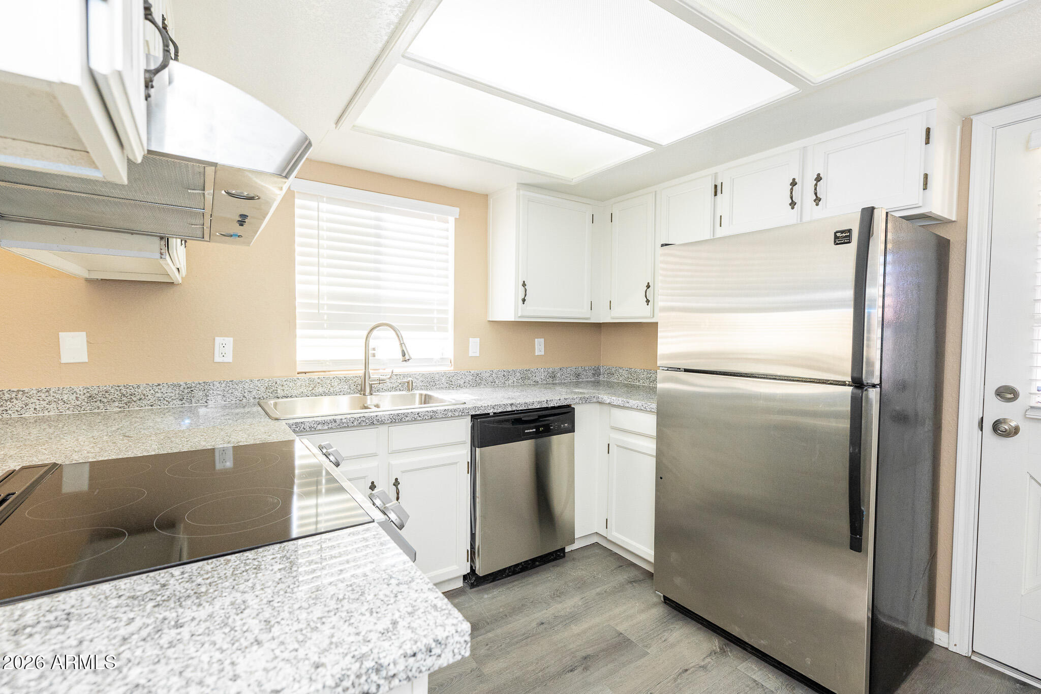 542 South Higley Road, Unit 104 Mesa, AZ 85206 - Photo 8 of 22 a kitchen with stainless steel appliances granite countertop a refrigerator and a sink