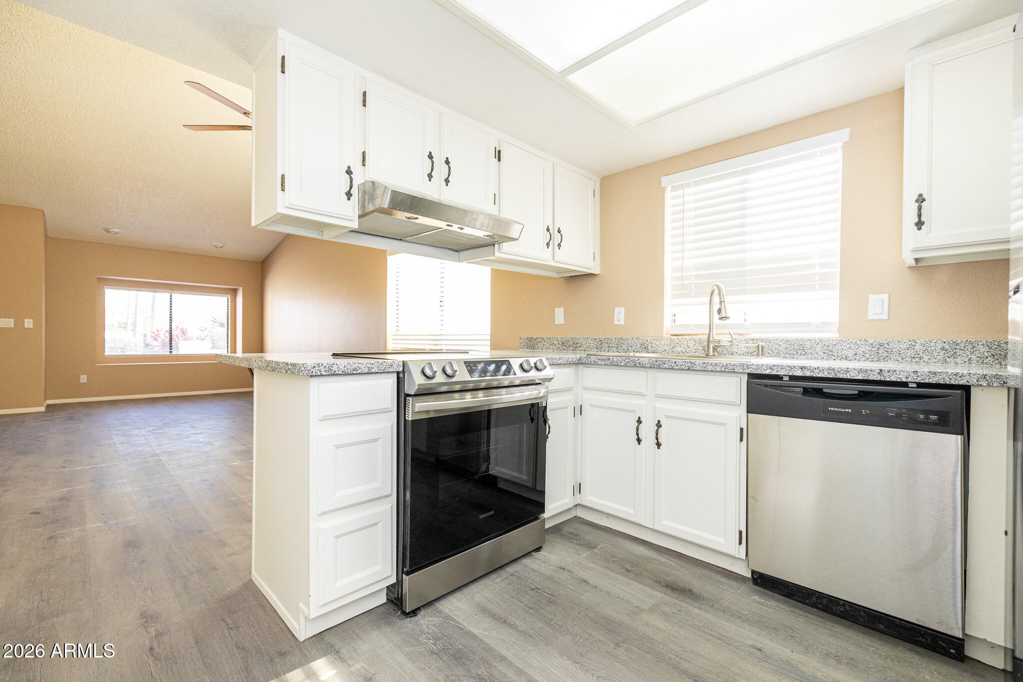 542 South Higley Road, Unit 104 Mesa, AZ 85206 - Photo 9 of 22 a kitchen with granite countertop a sink cabinets stainless steel appliances and a window