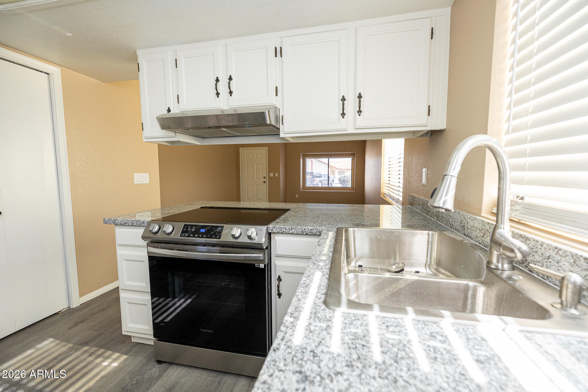 542 South Higley Road, Unit 104 Mesa, AZ 85206 - Photo 10 of 22 a kitchen with stainless steel appliances granite countertop a stove sink and cabinets