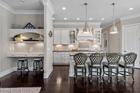 a kitchen with granite countertop a table chairs stove a sink and dishwasher