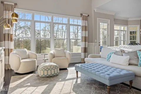 a living room with large couches and a dining table with wooden floor