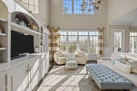 a living room with a fireplace furniture a flat screen tv and a fireplace