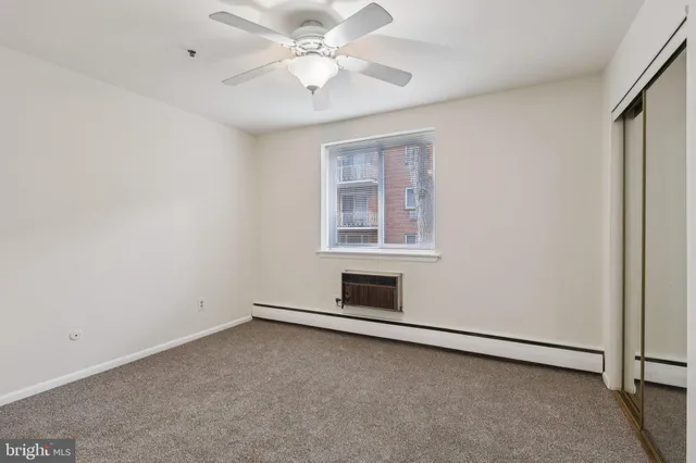 an empty room with a ceiling fan and windows