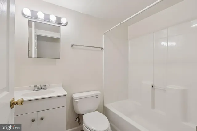 a bathroom with a sink mirror vanity and toilet