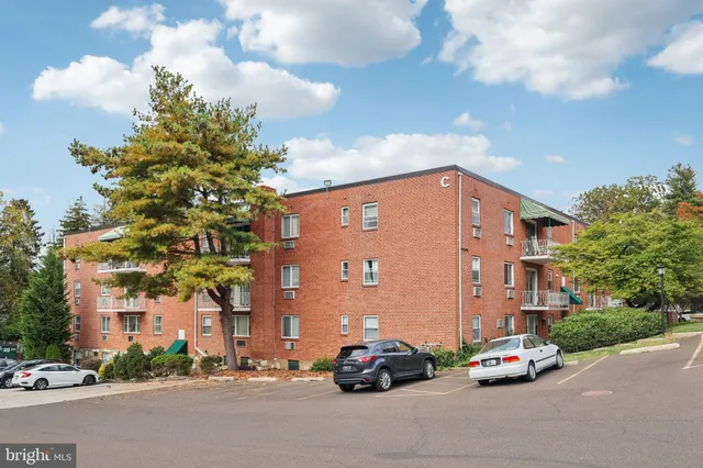 a car parked in front of a building with parked cars