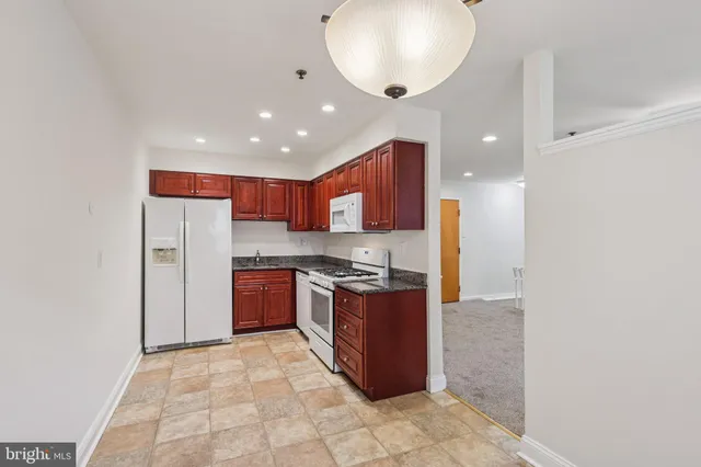 a large kitchen with stainless steel appliances granite countertop a stove and a refrigerator