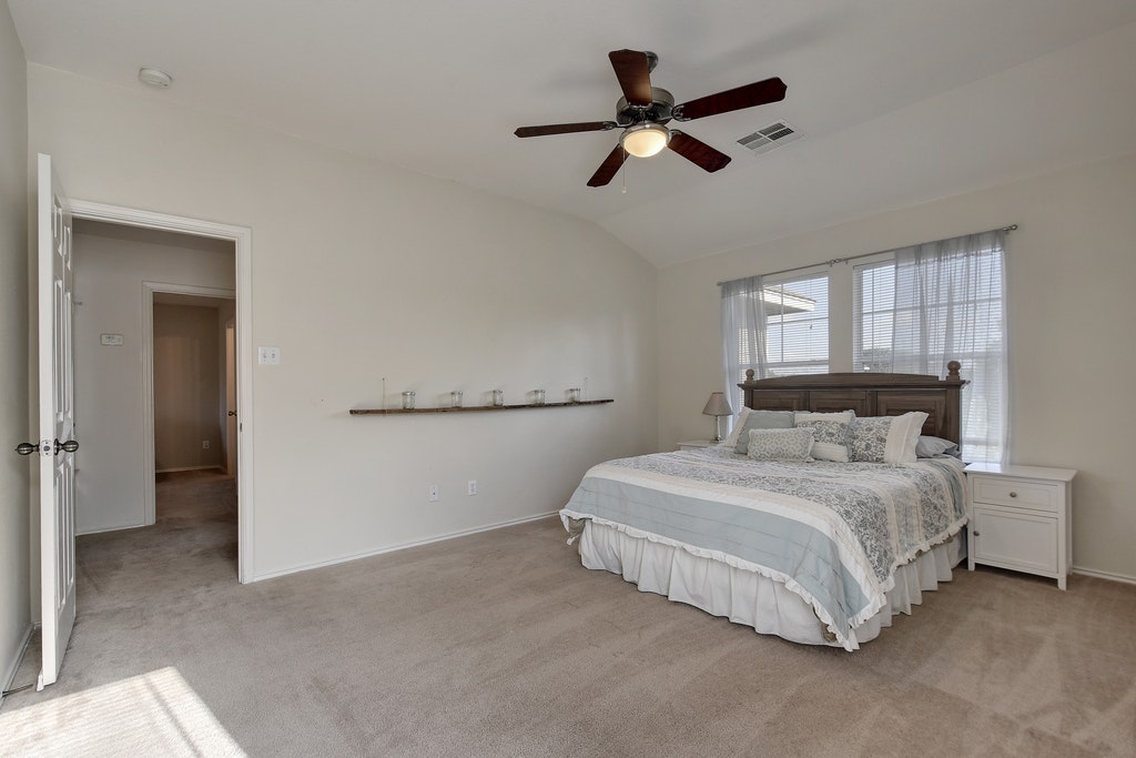 2201 Keepsake Drive Austin, TX 78745 - Photo 12 of 25 a bedroom with a bed and a ceiling fan