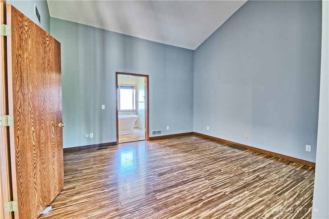 8711 Nicole Lane Springboro, OH 45066 - Photo 36 of 87 This primary bedroom features high vaulted ceilings and hardwood floors, with a private entry to the primary bathroom.