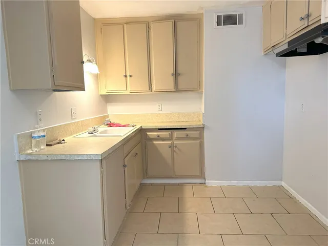 a utility room with a sink a cabinetry and a stove