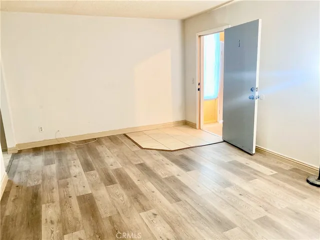 an empty room with wooden floor and a bathroom