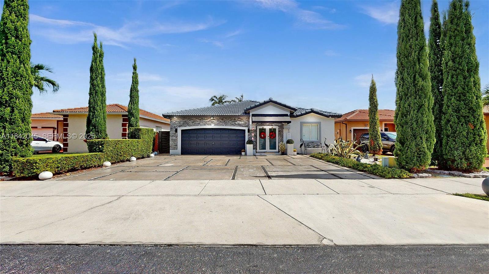 a front view of a building with a garden and plants