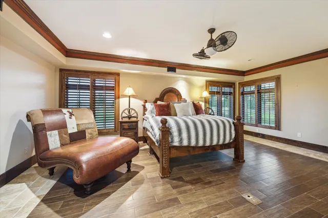 a bedroom with a bed a couch and large windows