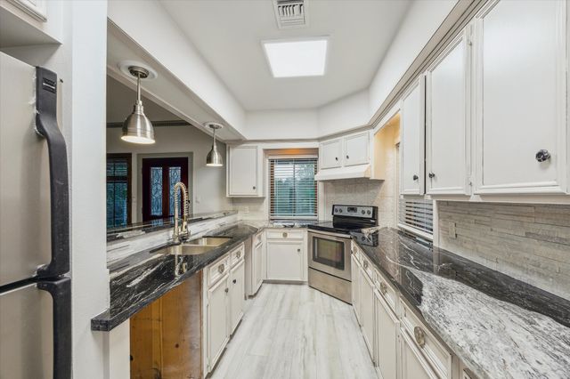 a kitchen with a sink stove and cabinets