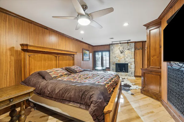 a bedroom with a bed dresser and a flat tv screen